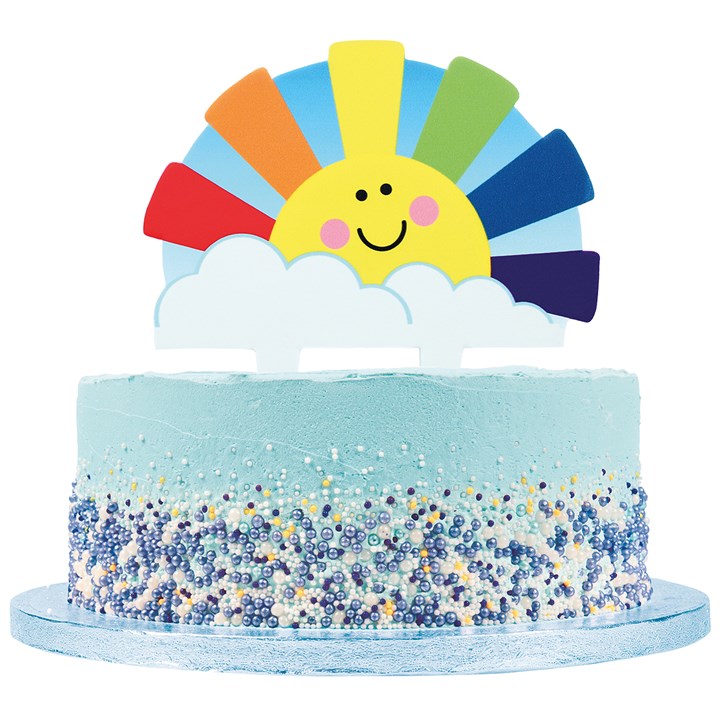 Colourful cake with a sun and rainbow topper on a white background