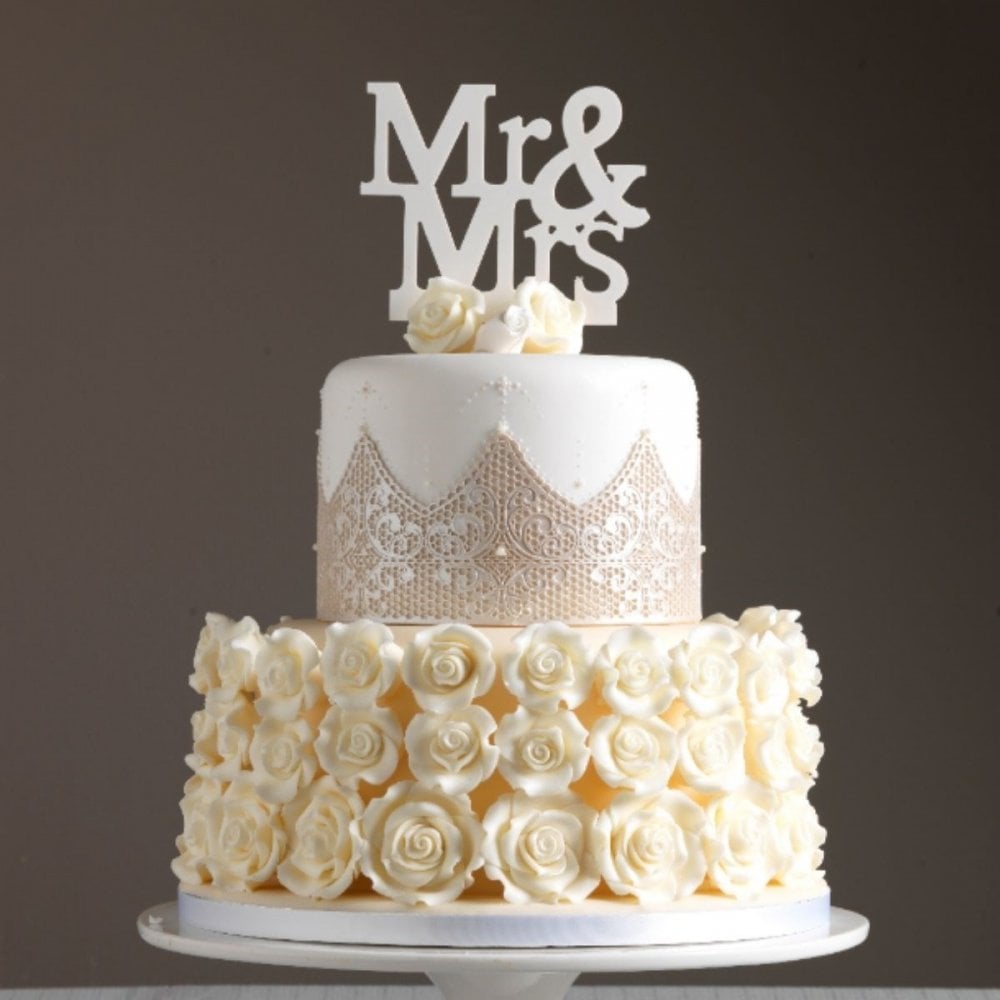 Wedding cake with 'Mr & Mrs' topper on a dark background