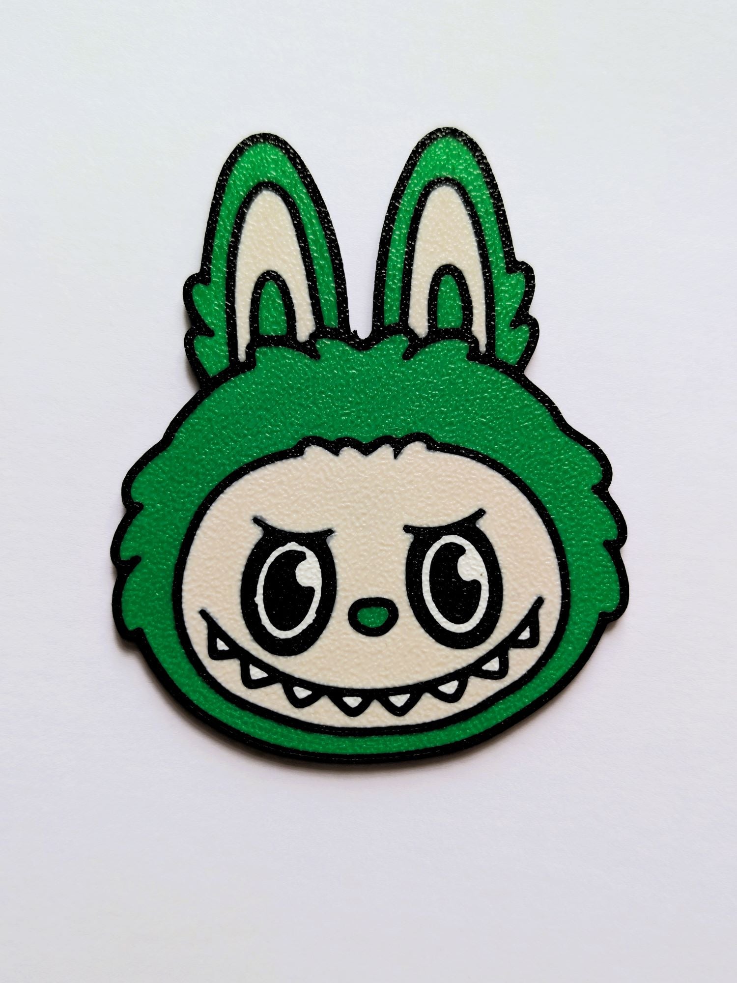 Green Labubu/Lafufu character with a grumpy expression on a white background