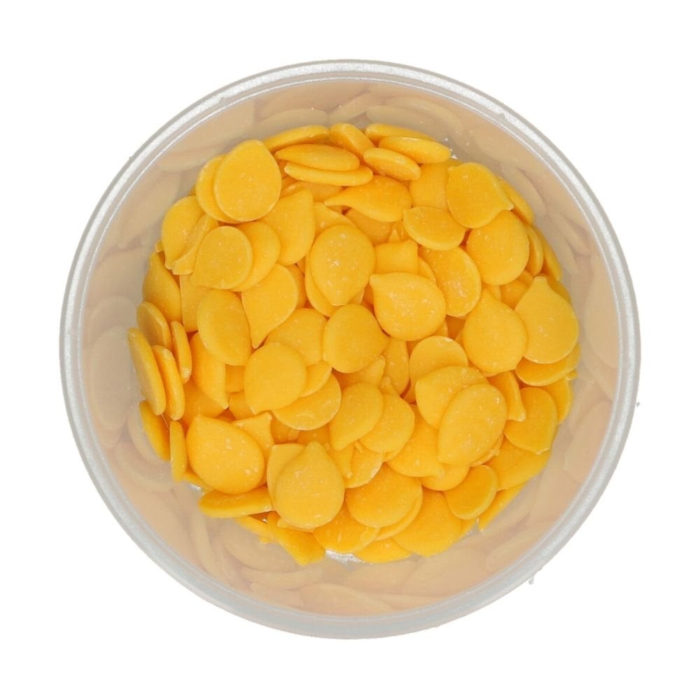 Clear container filled with yellow round wilton candy melts on a white background